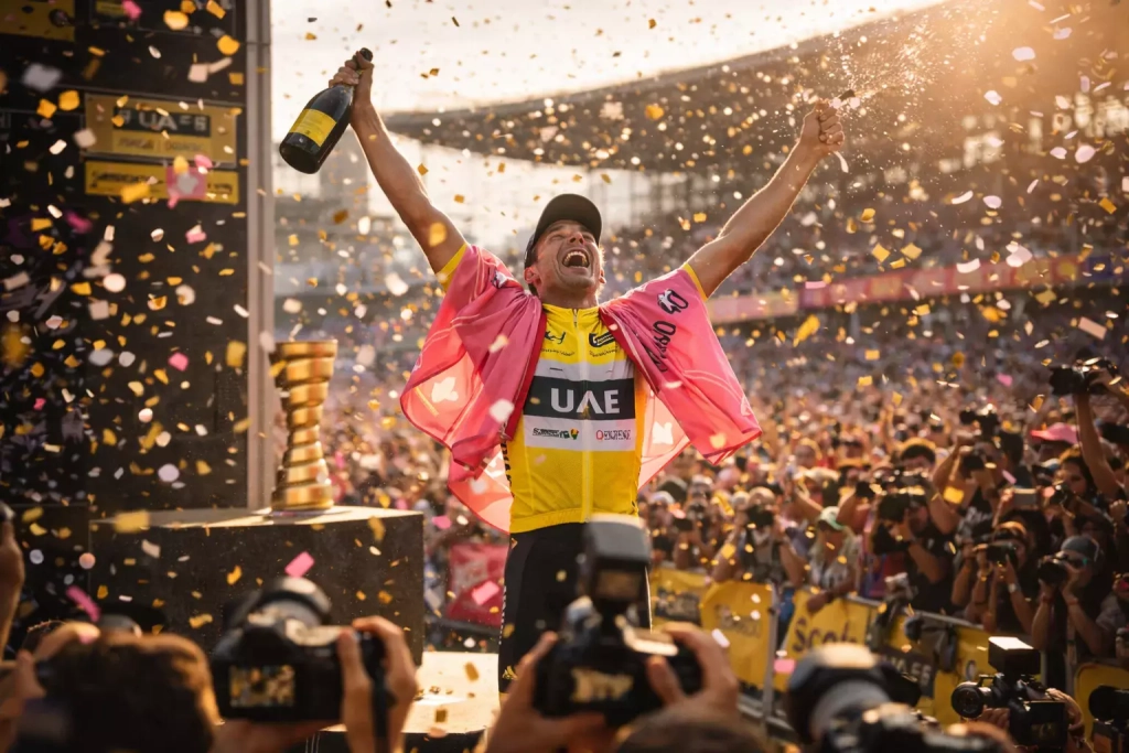 Ciclista solleva i trofei del Giro d'Italia e Tour de France in celebrazione